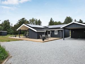 a black house with a deck and a patio at Seaside Haven Retreat - By Traum Ferienwohnungen in Skram