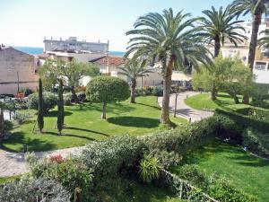 a park with palm trees and grass and bushes at Apartment Riviera Park by Interhome in Cannes