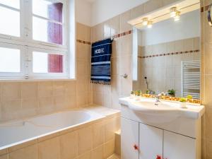 y baño con lavabo, bañera y espejo. en Apartment la République-1 by Interhome en Biarritz