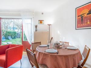 a dining room with a table and chairs and a couch at Apartment la République-1 by Interhome in Biarritz