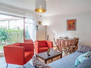 a living room with red chairs and a table at Apartment la République-1 by Interhome in Biarritz