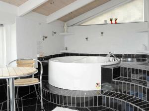 9 person holiday home in Ringk bing في سوندرفيغ: حمام مع حوض استحمام وطاولة