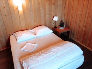 a bedroom with a bed and a table with a lamp at Chez Siouab in Saint-Hostien