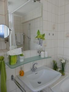 Baño blanco con lavabo y espejo en Haus Marija M en Badenweiler
