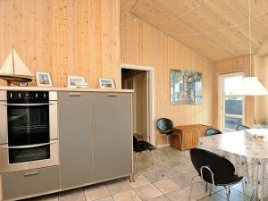 a kitchen with a table and a stove top oven at 8 person holiday home in Fan in Fanø