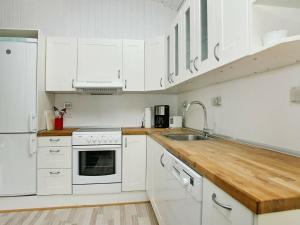 een keuken met witte kasten en een houten aanrecht bij 6 person holiday home in lb k in Ålbæk