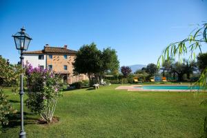 a house with a lamp in a yard with a pool at Villa Il Casone in Cortona