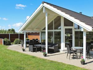 a pavilion with tables and chairs on a patio at 14 person holiday home in Idestrup in Marielyst