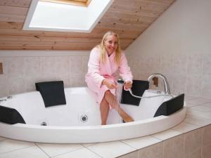 a woman sitting in a bath tub in a room at 14 person holiday home in Idestrup in Marielyst