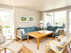 a living room with a blue couch and a table at 6 person holiday home in Pandrup in Rødhus