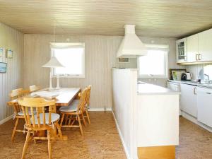 a kitchen and dining room with a table and chairs at 6 person holiday home in Pandrup in Rødhus