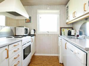 a kitchen with white appliances and a window at 6 person holiday home in Pandrup in Rødhus
