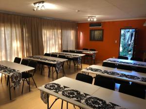uma sala de conferências com mesas, cadeiras e cortinas em JC Studios Ermelo em Ermelo