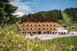 a large building in the middle of a field at Laguscei Dolomites Mountain Hotel in Arabba