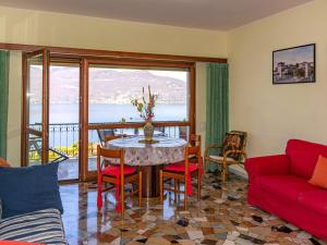 - un salon avec une table et un canapé rouge dans l'établissement Apartment Belmonte-1 by Interhome, à Brezzo