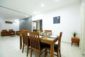 a dining room with a wooden table and chairs at Skyla Serviced Apartments in Hyderabad