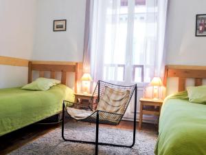 1 dormitorio con 2 camas, silla y ventana en Apartment Goélands by Interhome, en Biarritz