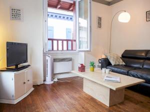 a living room with a couch and a tv at Apartment Goélands by Interhome in Biarritz