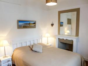 a bedroom with a bed with a mirror and a fireplace at Apartment Goélands by Interhome in Biarritz