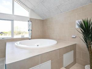 a large bathroom with a tub and a plant at Holiday Home in Zealand with Private Pool in Marielyst