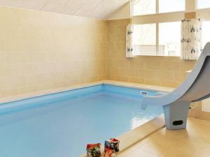 a swimming pool in a room with a slide at Holiday Home in Zealand with Private Pool in Marielyst
