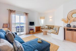 a living room with a blue couch and a tv at Albufeira Family Holidays with Pool View in Albufeira