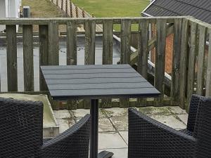 a picnic table and two chairs on a balcony at 6 person holiday home in Lemvig in Ferring