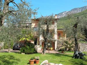 a house with a yard with trees in front of it at Apartment Villa Rizzardi-1 by Interhome in Malcesine