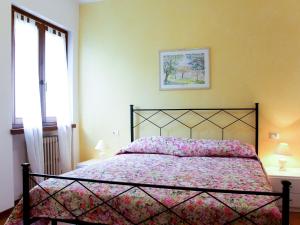 マルチェージネにあるApartment Villa Rizzardi-1 by Interhomeのベッドルーム1室(ピンクのベッドカバー付)、窓が備わります。