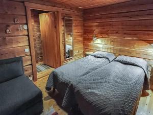 ein Schlafzimmer mit einem Bett in einer Holzhütte in der Unterkunft Holiday Home Sompsanniemi by Interhome in Ruka