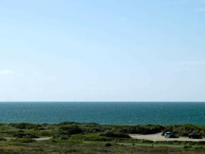 ブラーバンドにある24 person holiday home in Bl vandの海の景色を望むビーチに駐車した車