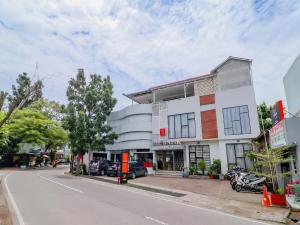 a building on a street with cars parked in front of it at Super OYO Collection O 31 The Batik Bed And Coffee Bandung in Bandung