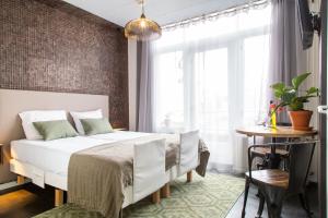 a bedroom with a white bed and a table at Hotel Pannenkoekhuis Vierwegen in Domburg