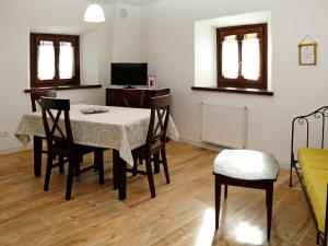 una sala da pranzo con tavolo, sedie e TV di Apartment Cjase da Maestre-1 by Interhome a Raveo