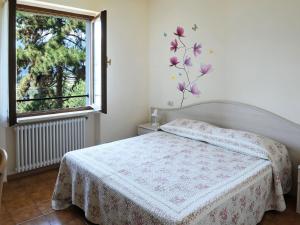 una camera da letto con un letto con un fiore sul muro di Apartment Belvedere-2 by Interhome a Malcesine