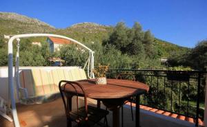 d'une table et de chaises en bois sur un balcon avec vue sur les montagnes. dans l'établissement Villa Ro-Ela, à Trsteno