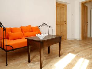 an orange couch and a table in a living room at Apartment Cjase da Maestre-2 by Interhome in Raveo