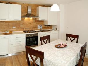 a kitchen with white cabinets and a table with a plate on it at Apartment Cjase da Maestre-2 by Interhome in Raveo