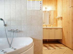 a bathroom with a tub and a toilet and a sink at 8 person holiday home in Nex in Spidsegård