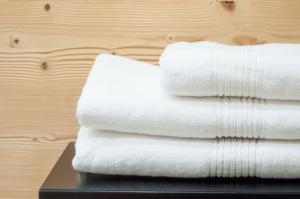a stack of white towels sitting on a table at Beim Dorfbach I DIE HOFCHALETS in Kressbronn am Bodensee
