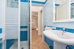 a blue bathroom with a sink and a shower at Shanti House Olbia in Olbia +17 photos