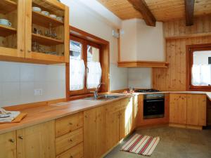 a kitchen with wooden cabinets and a sink at Holiday Home Stali di Ettore by Interhome in Ovaro