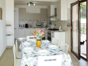 een keuken met een tafel met borden en bloemen erop bij Apartment La Pineta - SLR112 by Interhome in Costarainera