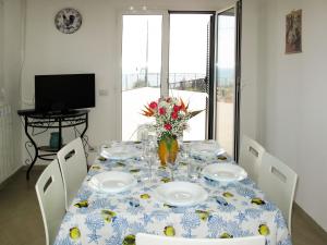 een eettafel met een blauw en wit tafelkleed bij Apartment La Pineta - SLR112 by Interhome in Costarainera