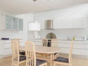 ロモ・キルケビーにある6 person holiday home in R mの白いキッチン(木製テーブル、椅子付)