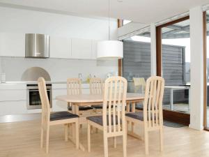 ロモ・キルケビーにある6 person holiday home in R mのダイニングルーム(木製テーブル、椅子付)