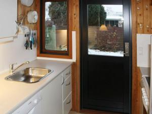 a kitchen with a sink and a black door at 6 person holiday home in Str by in Strøby