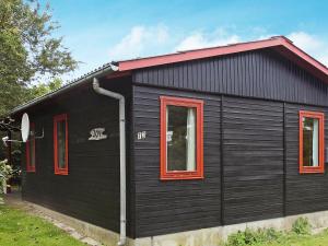 ノーポにある6 person holiday home in Nordborgの赤窓・赤屋根の黒い家