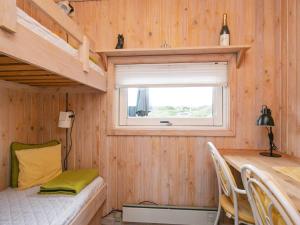 ブロックフスにあるHoliday home Blokhus Xの二段ベッドとデスクが備わる小さな家です。