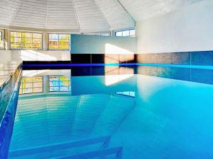 a swimming pool with blue water in a building at 12 person holiday home in V ggerl se in Marielyst